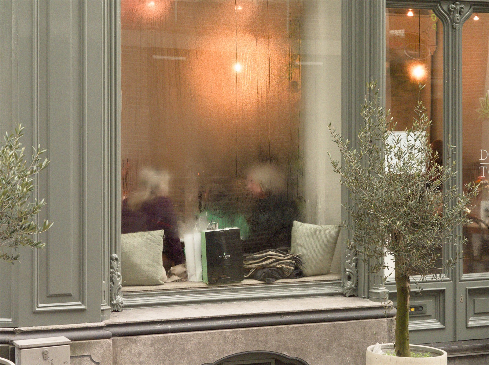 Person behind a shop window with reflections.